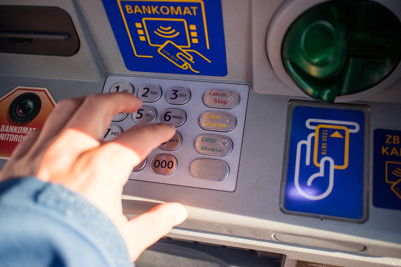 Uomo che utilizza uno smartphone per prelevare denaro, senza Bancomat.
